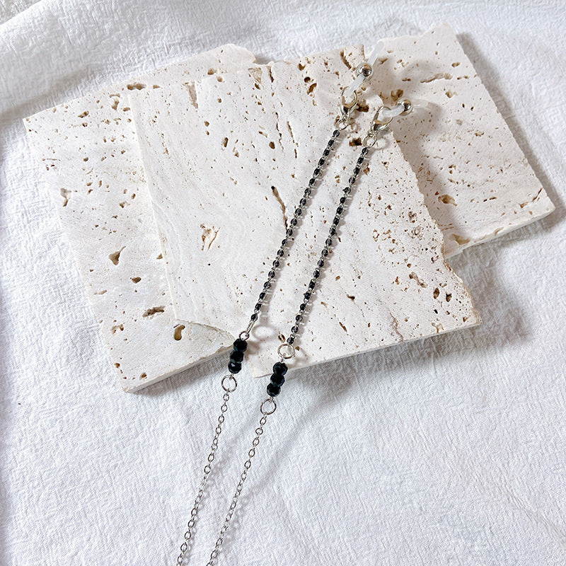 Close-up of black pearl glasses chain. Elegant and delicate design, a versatile women's eyewear accessory.