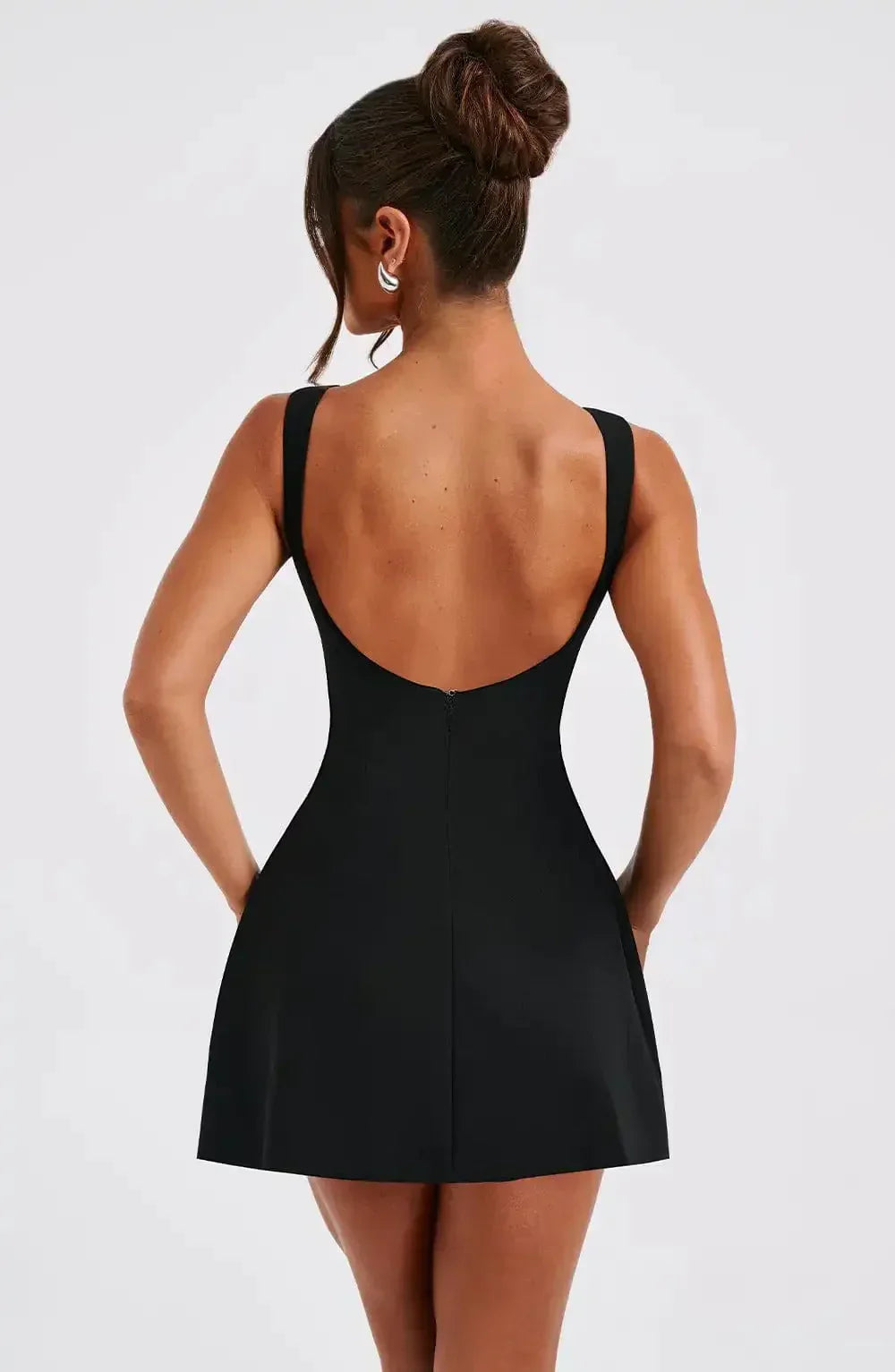 Chic women's sleeveless A-line mini dress, black & white boat neck design. Versatile for day to night events.