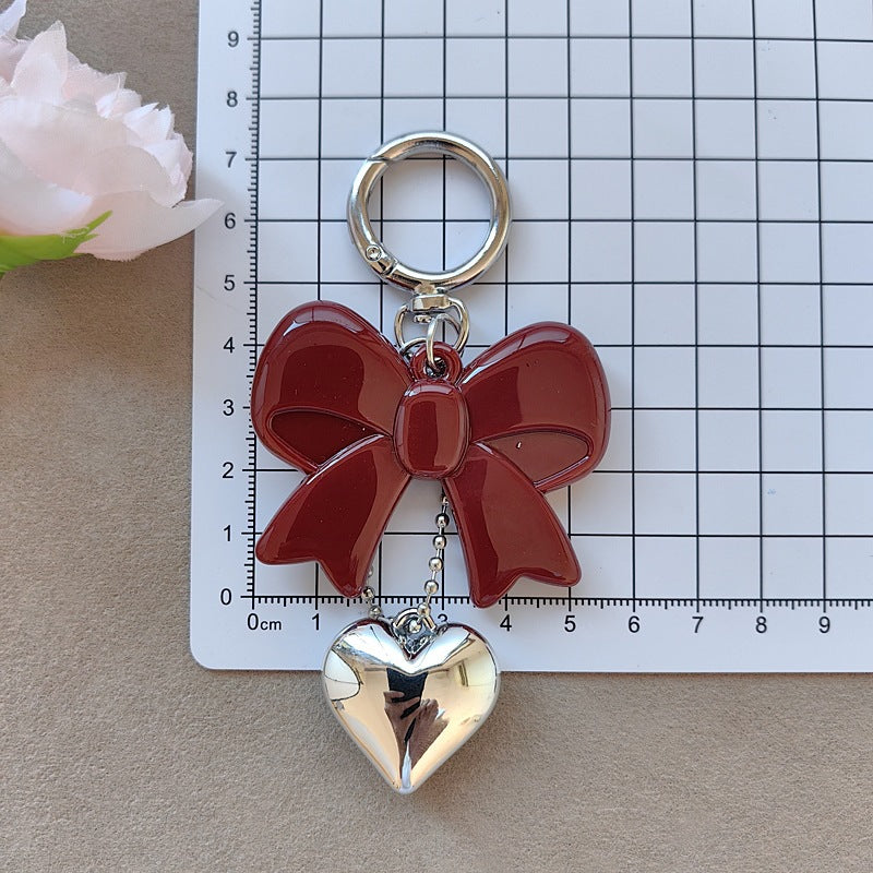 Cute women's bow and heart charm keychain, a fashionable and elegant accessory for keys or handbag.