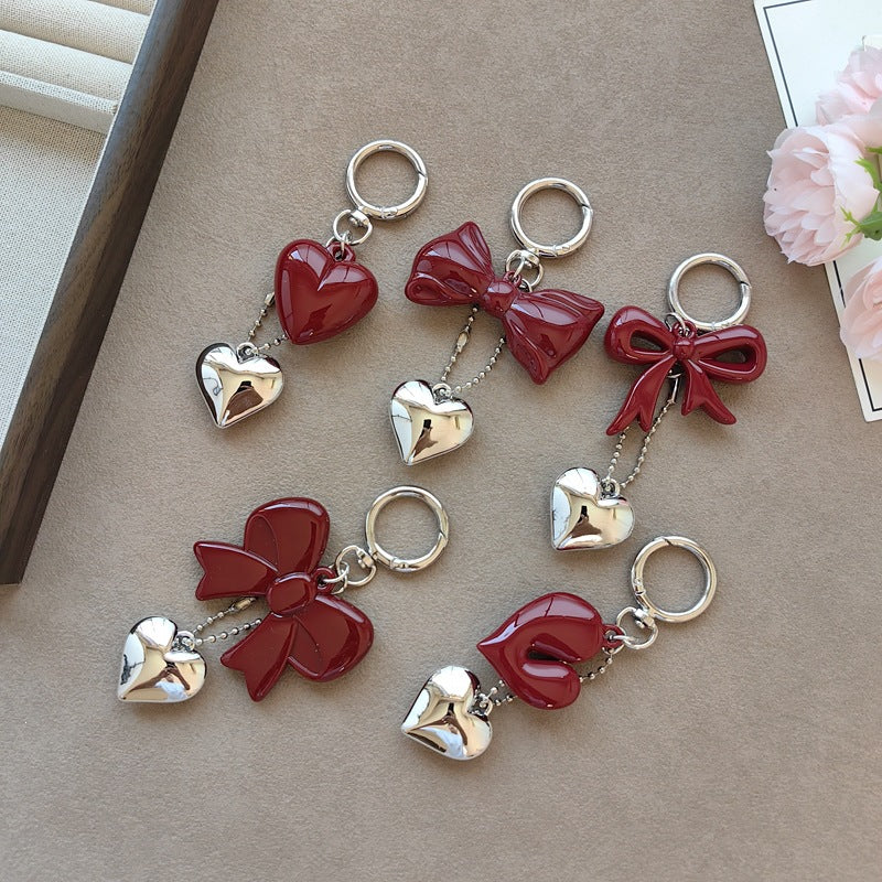 Fashionable women's keychain with bow and heart charm. Stylish accessory for keys and handbags.