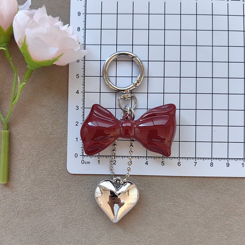 Women's elegant bow & heart keychain accessory, a stylish bag charm and key holder for fashion lovers.