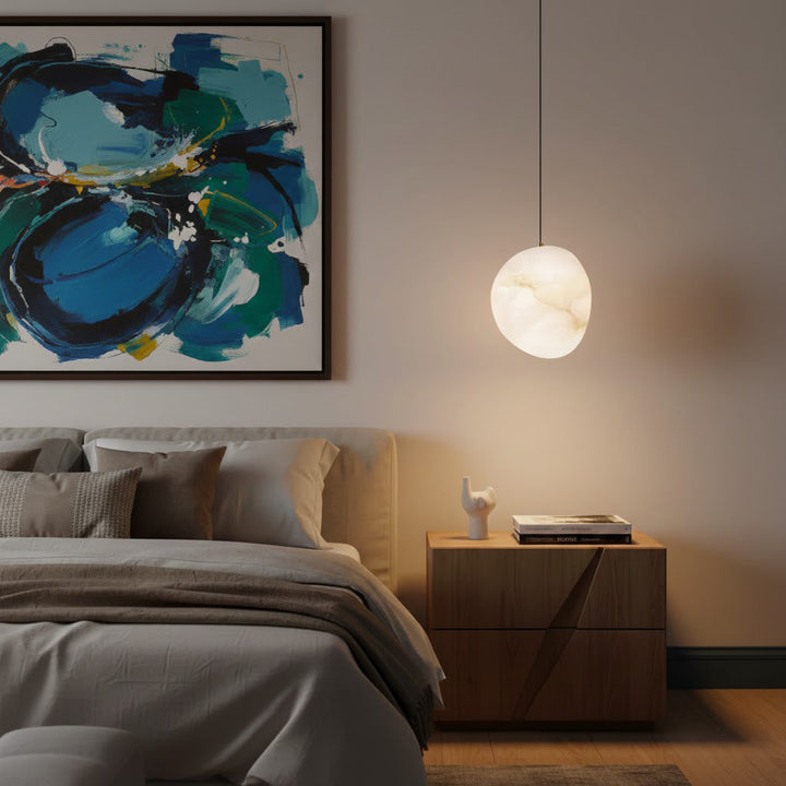 Elegant brass pendant light, organic pebble form, perfect for modern minimalist spaces.