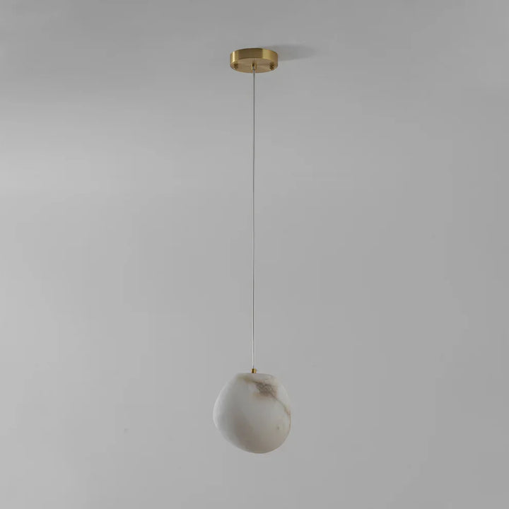 Ambient brass pendant light, pebble shape, ideal for modern home decor aesthetics.