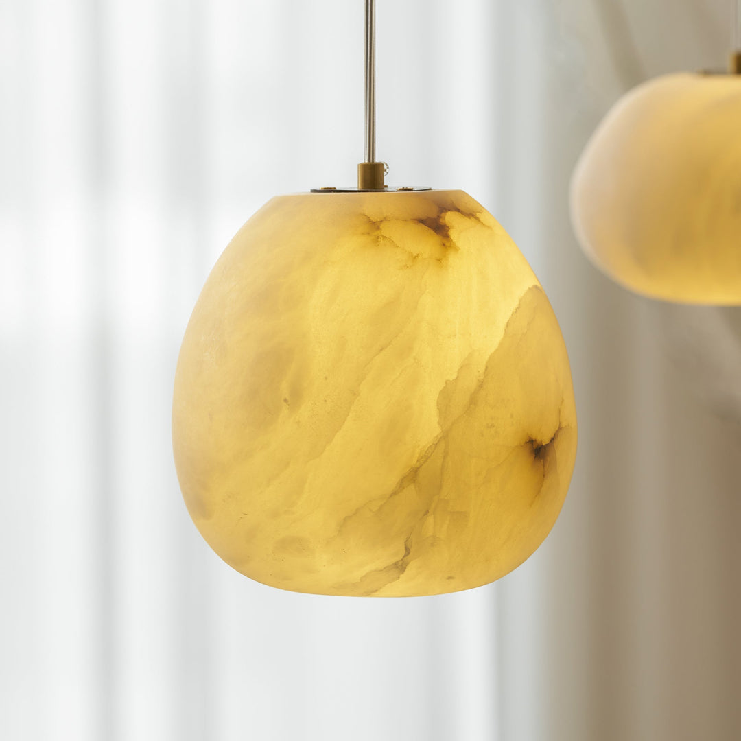 Modern organic brass pebble pendant, sleek design, ideal for contemporary ambient light.