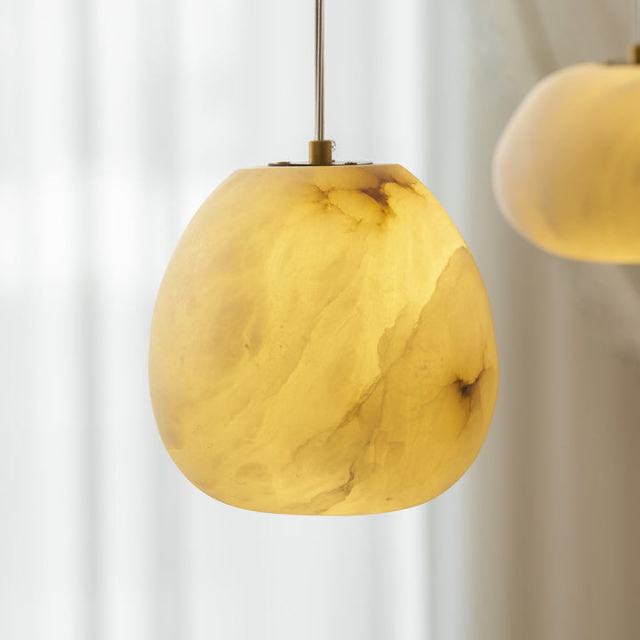 Modern organic brass pebble pendant, sleek design, ideal for contemporary ambient light.