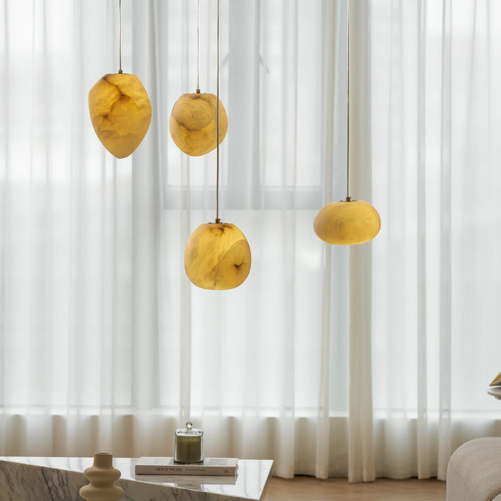 Contemporary brass pendant lamp, elegant pebble shape, perfect for modern interiors.