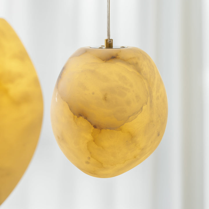 Contemporary brass pendant, pebble shape, provides beautiful ambient lighting for decor.