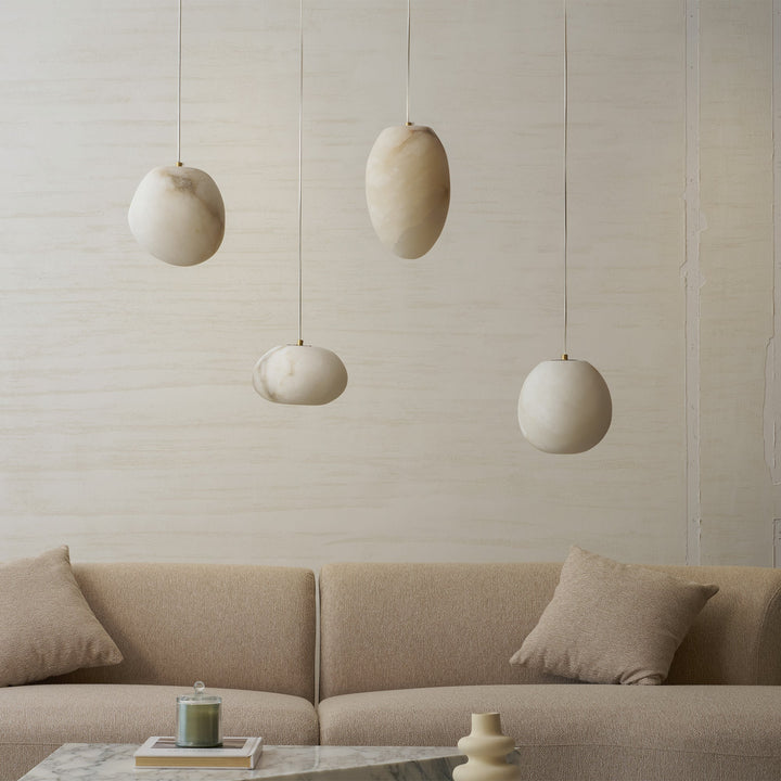 Organic brass pebble pendant lamp, minimalist, offers a soft ambient glow to spaces.