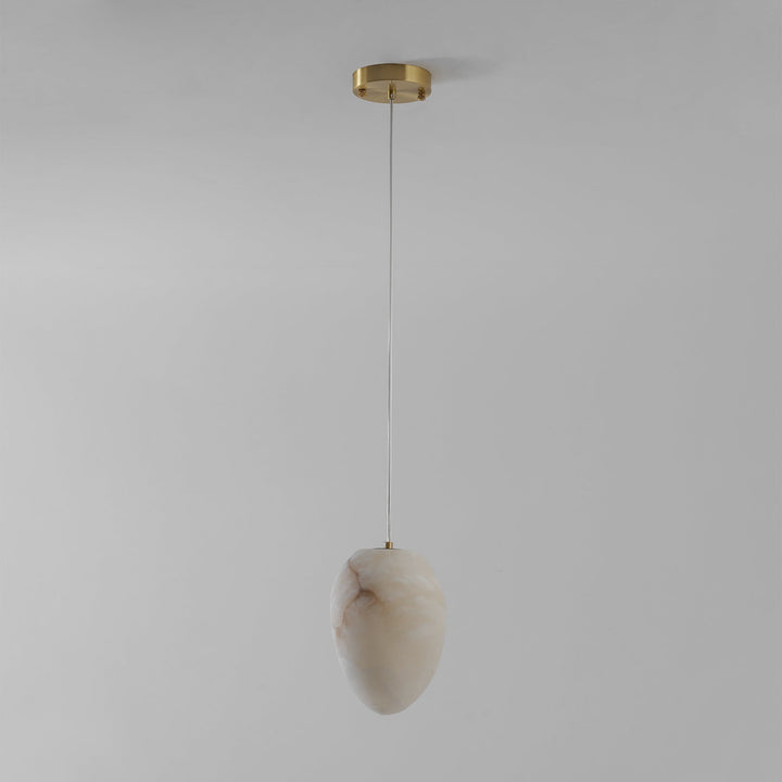 Serene interior brass pebble pendant, modern minimalist design, high-quality lighting.