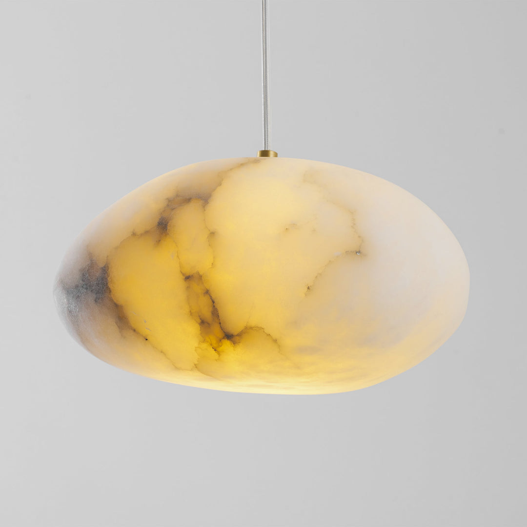 Organic brass pebble pendant, contemporary design, enhances serene interior aesthetics.