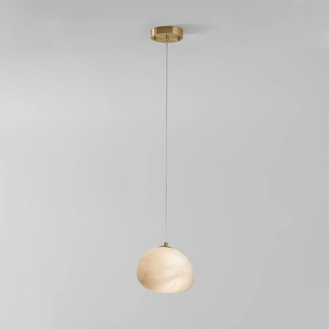 Serene brass pebble pendant lamp, modern design, adds ambient light to home interiors.