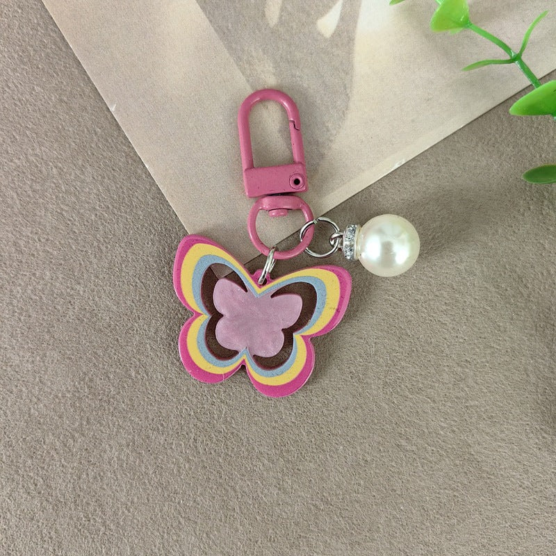 Chic butterfly and pearl keychain, a versatile women's accessory and elegant gift idea.