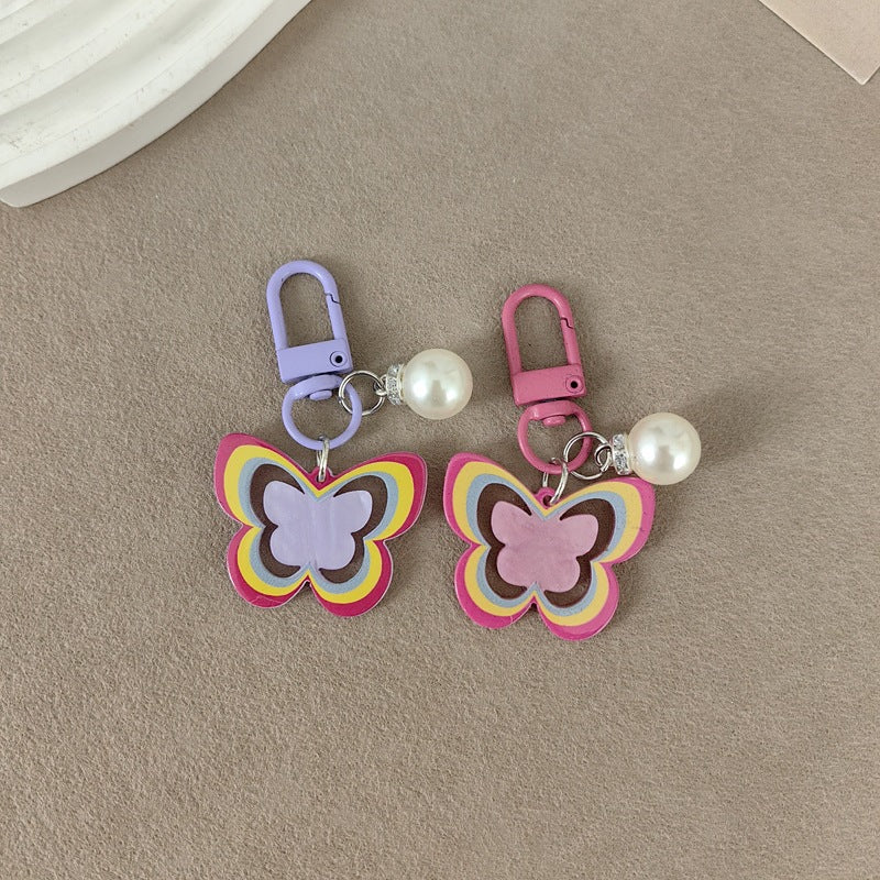 Women's elegant butterfly and pearl purse charm, perfect accessory for handbags or keys.