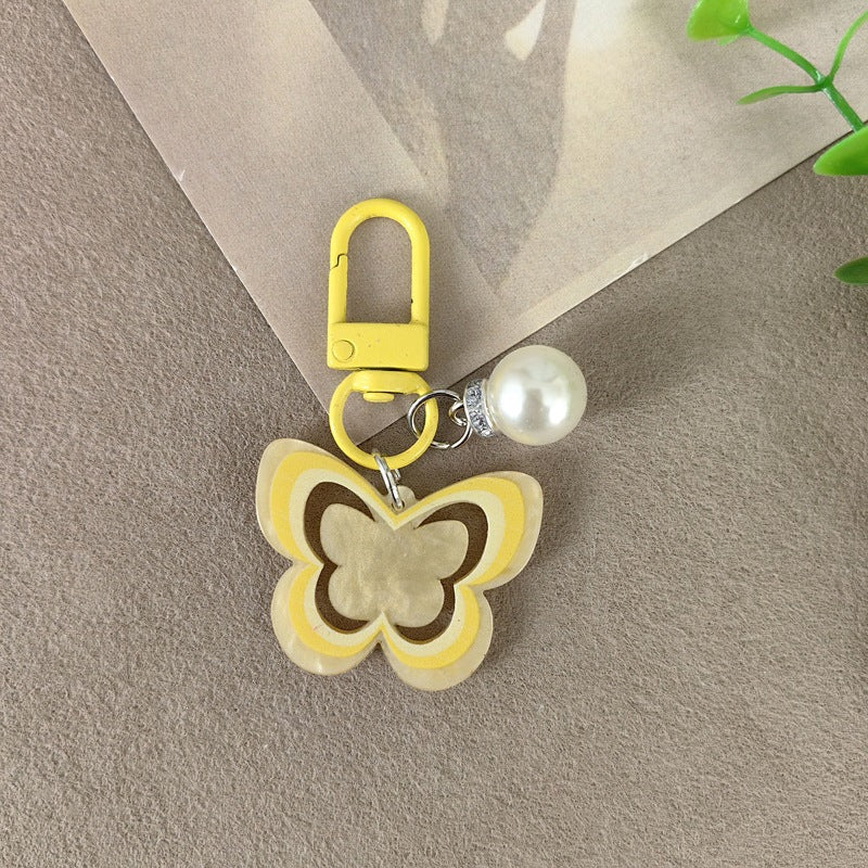Delicate butterfly design keychain with pearl accents, a fashionable women's accessory.
