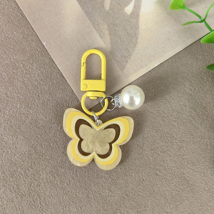 Delicate butterfly design keychain with pearl accents, a fashionable women's accessory.