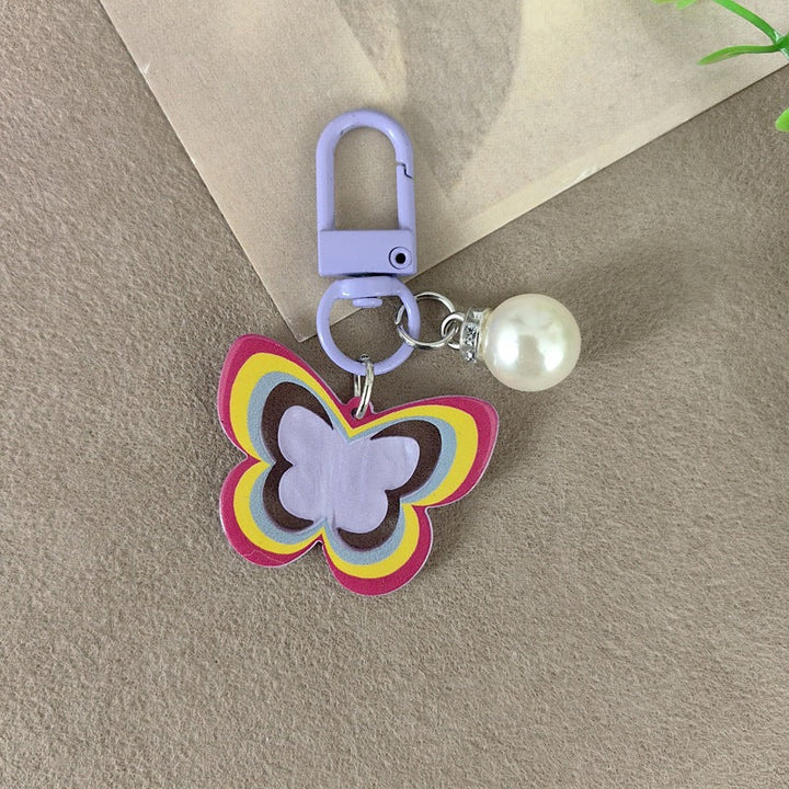 Lustrous faux pearl and butterfly pendant keychain, a women's accessory for keys or gifts.