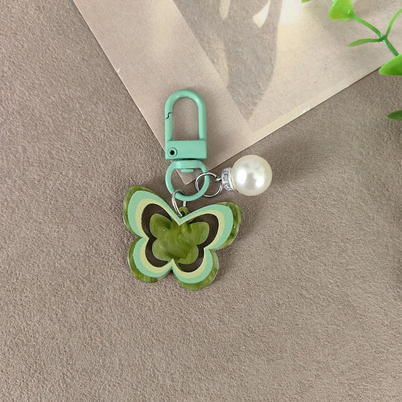 Vibrant butterfly accessory with pearl details, an elegant women's bag charm or keychain.