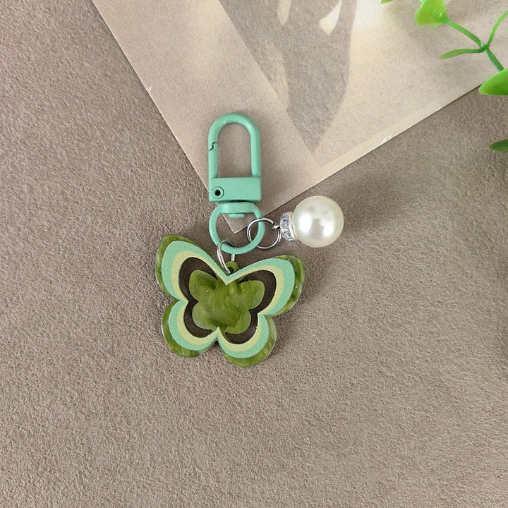 Vibrant butterfly accessory with pearl details, an elegant women's bag charm or keychain.