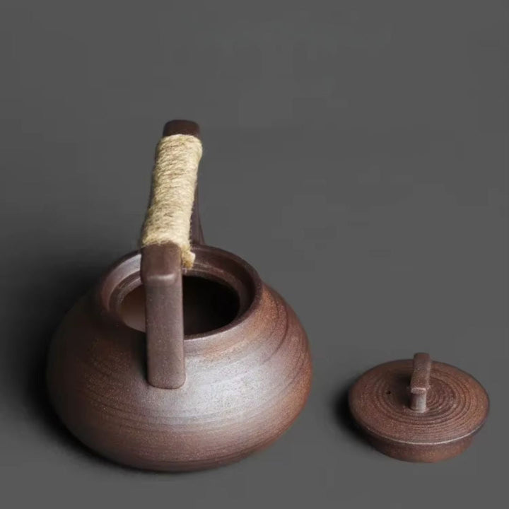Close-up of a handcrafted ceramic teapot and its warming stand, ideal for hot tea lovers.