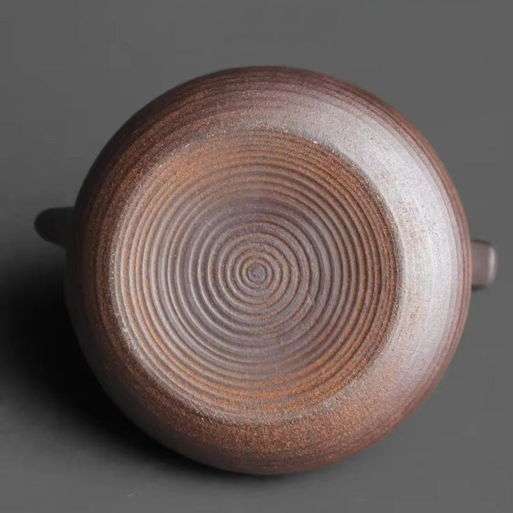 Detailed ceramic teapot with a unique warmer base, a key piece of handcrafted tea accessories.