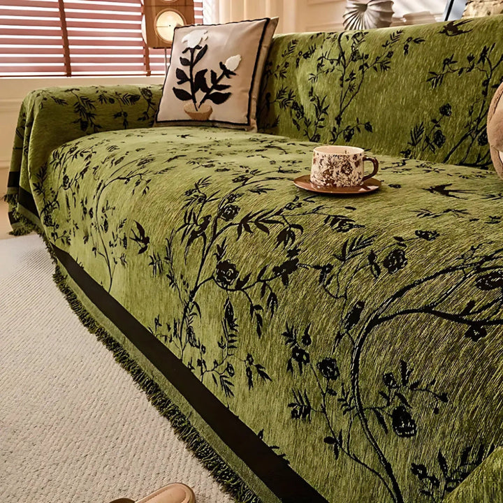 Elegant chenille throw blanket with a detailed floral pattern and fringe trim, perfect for luxury home decor.
