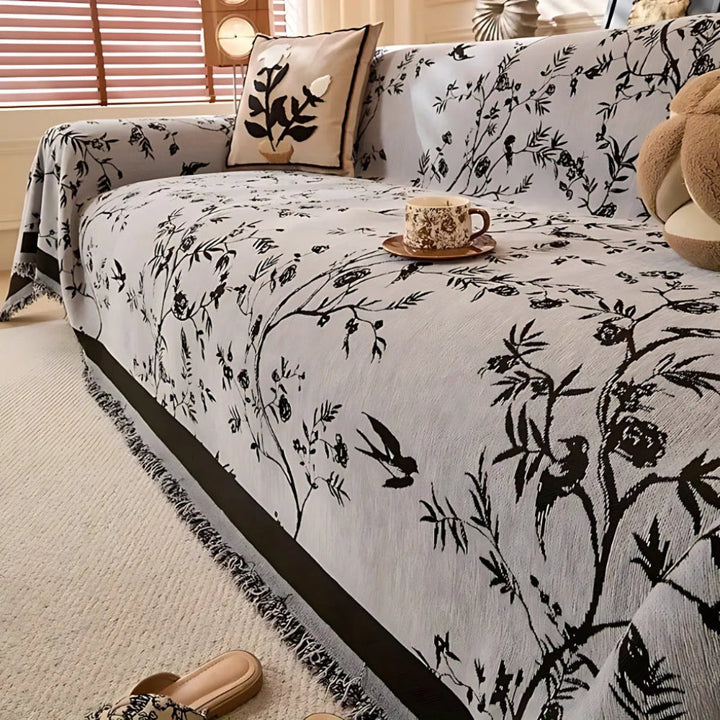 Cozy floral chenille throw blanket with fringe, ideal as a sofa cover or furniture protector in living room.