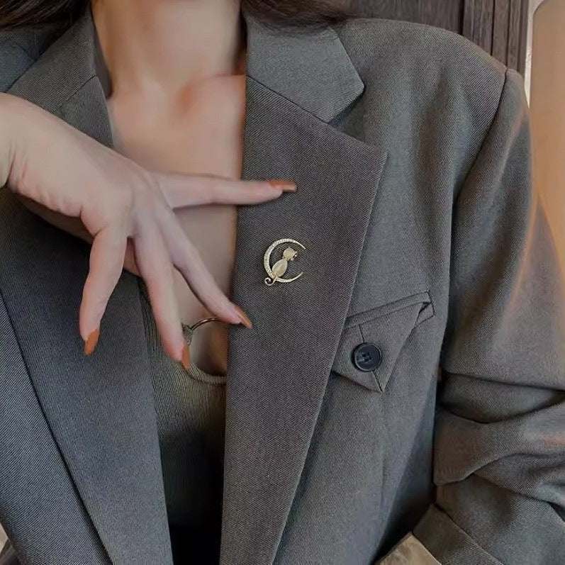 Close-up of sparkling cubic zirconia cat brooch. Detailed feline accessory, an elegant pin for women.