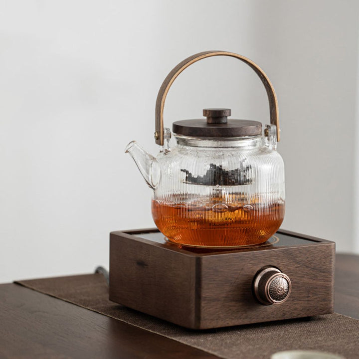 Essential kitchen accessory: electric tea warmer with walnut base ensures optimal tea temperature & flavor.