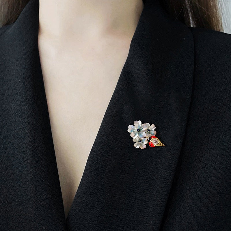 Elegant floral ladybug brooch for women, adorned with sparkling crystal accents and rich enamel.
