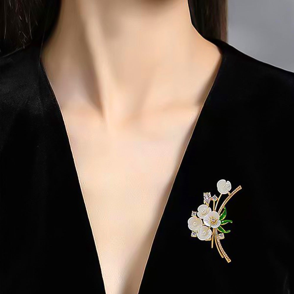 Elegant floral rhinestone brooch pin with pearls for women's dresses, a sophisticated accessory.