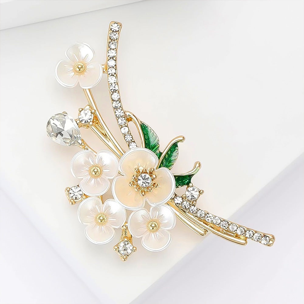 Intricate floral brooch featuring shimmering rhinestones and lustrous faux pearls, elegant women's jewelry.