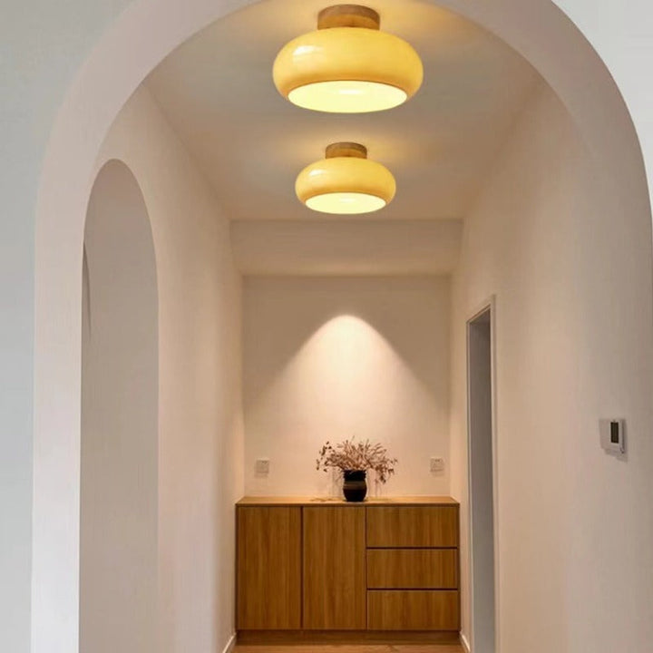 Low-profile flush mount ceiling fixture. Combines real wood accents & a clean glass diffuser. Elegant & space-saving.