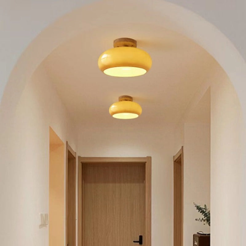 Stylish modern flush mount ceiling light with a wood frame & elegant glass shade for living rooms.