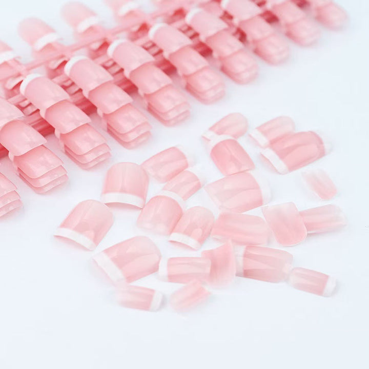Women's instant French tip press-on nails in classic pink for an elegant, quick beauty manicure. Fake reusable nails.