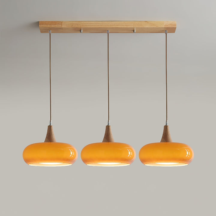Contemporary glass & wood pendant light with black metal details. Modern kitchen lighting.