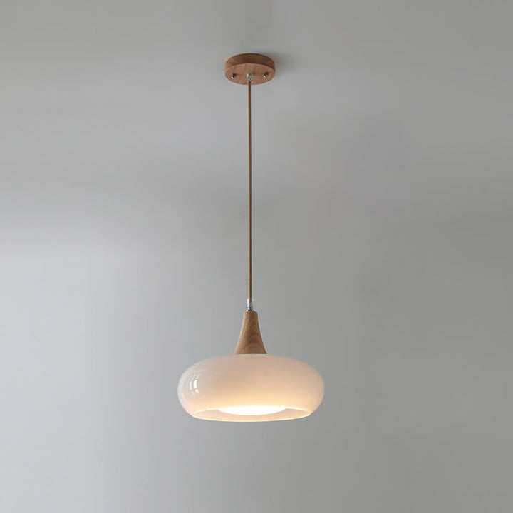 Stylish glass and wood pendant light for a sleek kitchen design. Modern and functional.