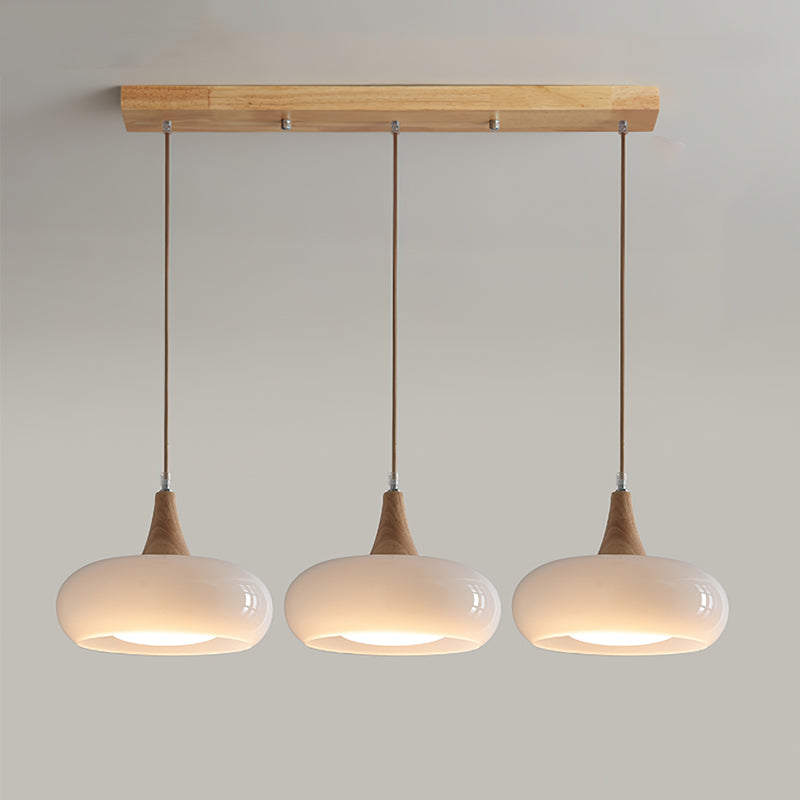Elegant pendant light featuring a clear glass shade and natural wood detail. Modern design.