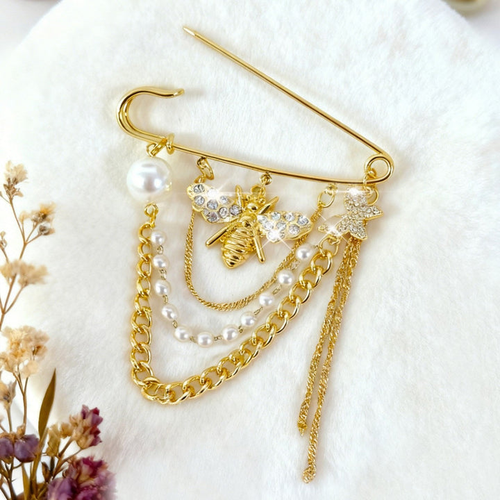 Exquisite pearl & crystal bee brooch, a golden safety pin style jewelry accessory for an elegant outfit.