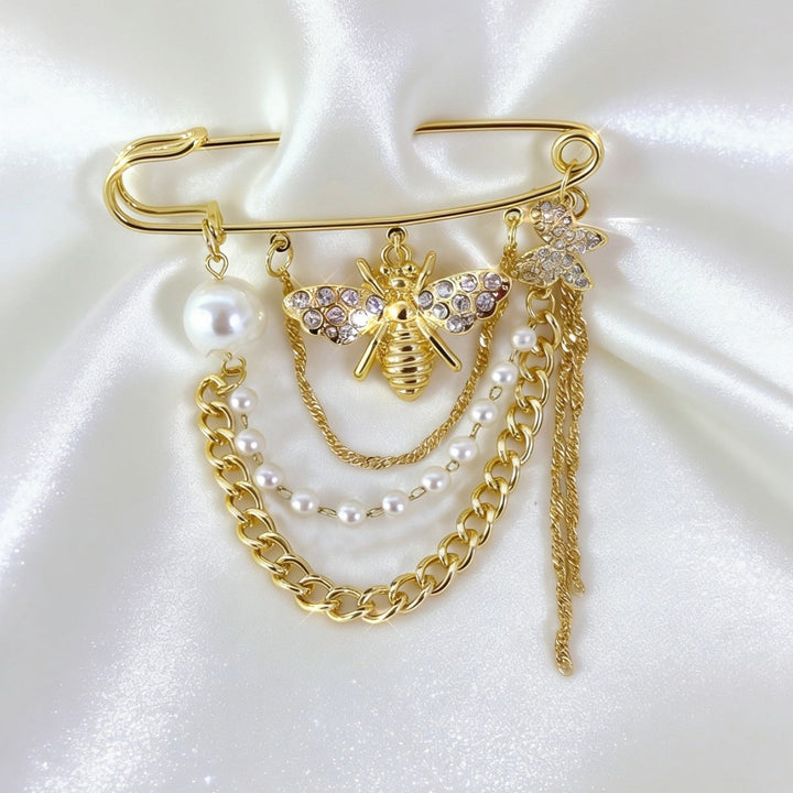Detailed gold bee safety pin brooch adorned with lustrous pearls & shimmering crystals. Perfect elegant accessory.