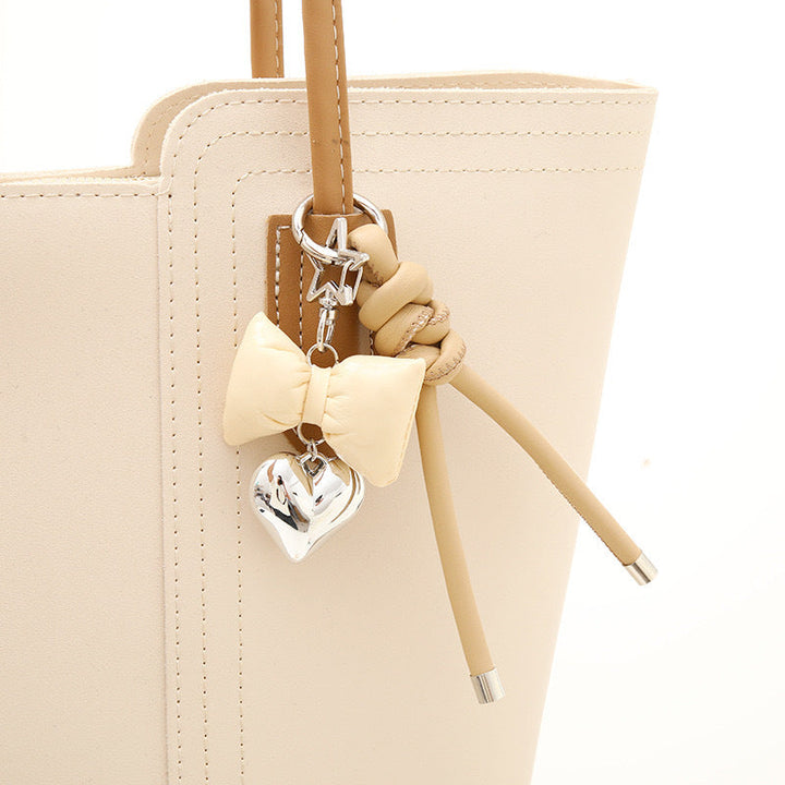 Stylish silver bow & heart key holder, a chic women's accessory.