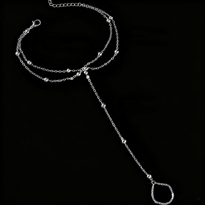 Close-up: Elegant gold chain ankle bracelet with white bead detail, adjustable for women's summer style.