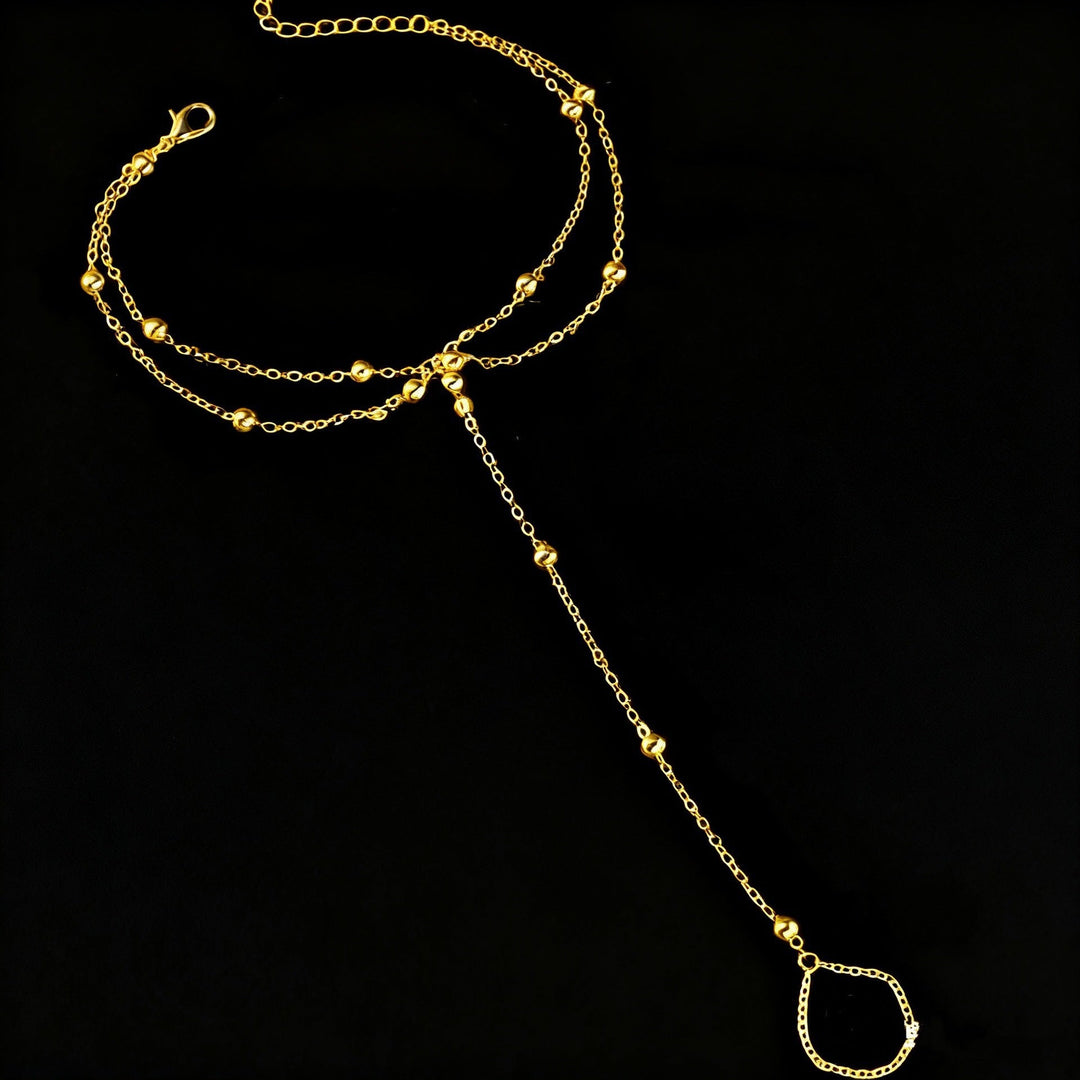 Women's fashion model wearing an elegant adjustable gold beach anklet with white elements, summer style.
