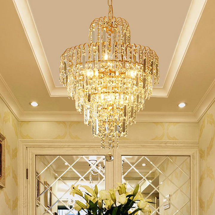 Classic tiered gold chandelier featuring cascading crystals. Perfect luxury lighting & elegant home decor statement piece.