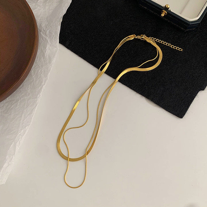 Close-up of a stunning gold double strand snake chain necklace, an elegant layered accessory for her.