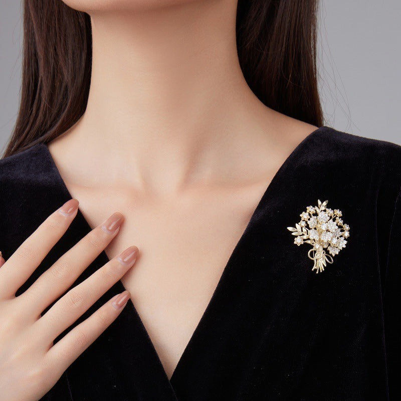Elegant gold flower brooch with sparkling crystals, perfect women's fashion jewelry accessory.