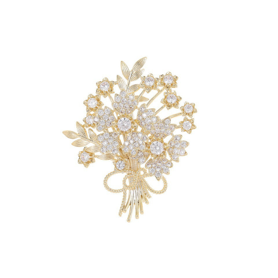 Delicate gold flower pin featuring sparkling crystals, a charming and elegant women's jewelry piece.