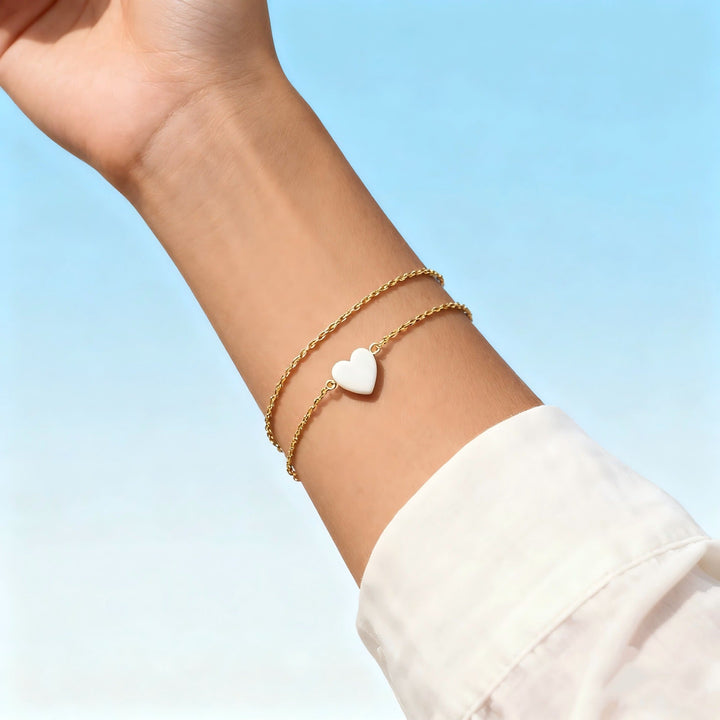 Close-up of the delicate gold heart charms on an elegant women's bracelet. Dainty jewelry detail.