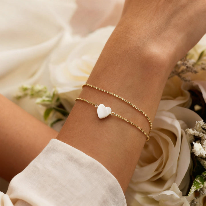 Beautiful gold heart charm bracelet for women, presented as an elegant anniversary gift. Love symbol jewelry.