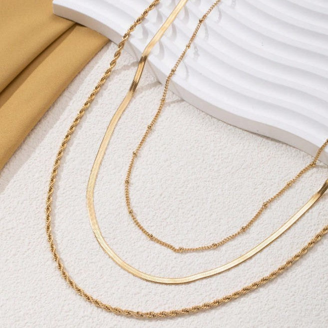 Close-up of a women's elegant layered gold chain necklace, showcasing the intricate multi-chain design.