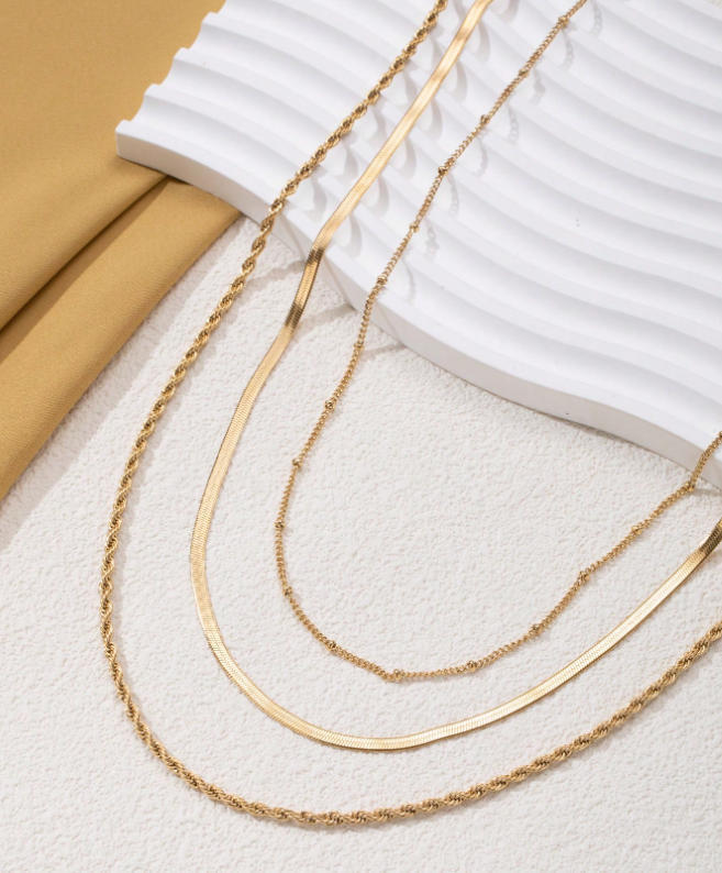 Model wearing an elegant women's gold layered necklace. This chic multi-chain design enhances her sophisticated style.